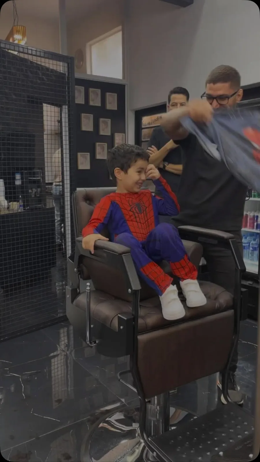 Menino fantasiado de Homem-Aranha na cadeira da barbearia