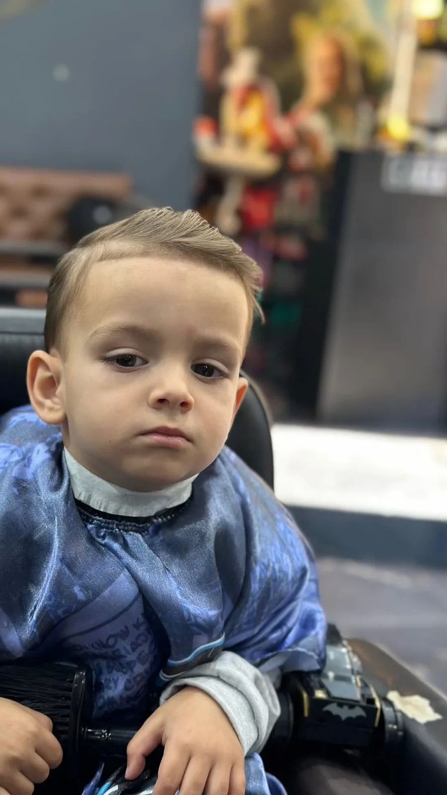 Criança na cadeira com o corte pronto